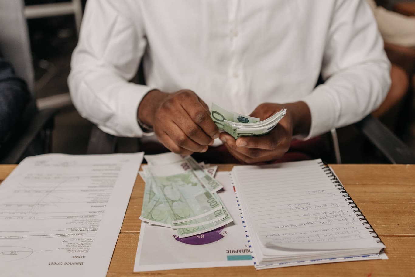 Bürotisch mit Finanzdokumenten und mehreren Banknoten verschiedener Währungen
