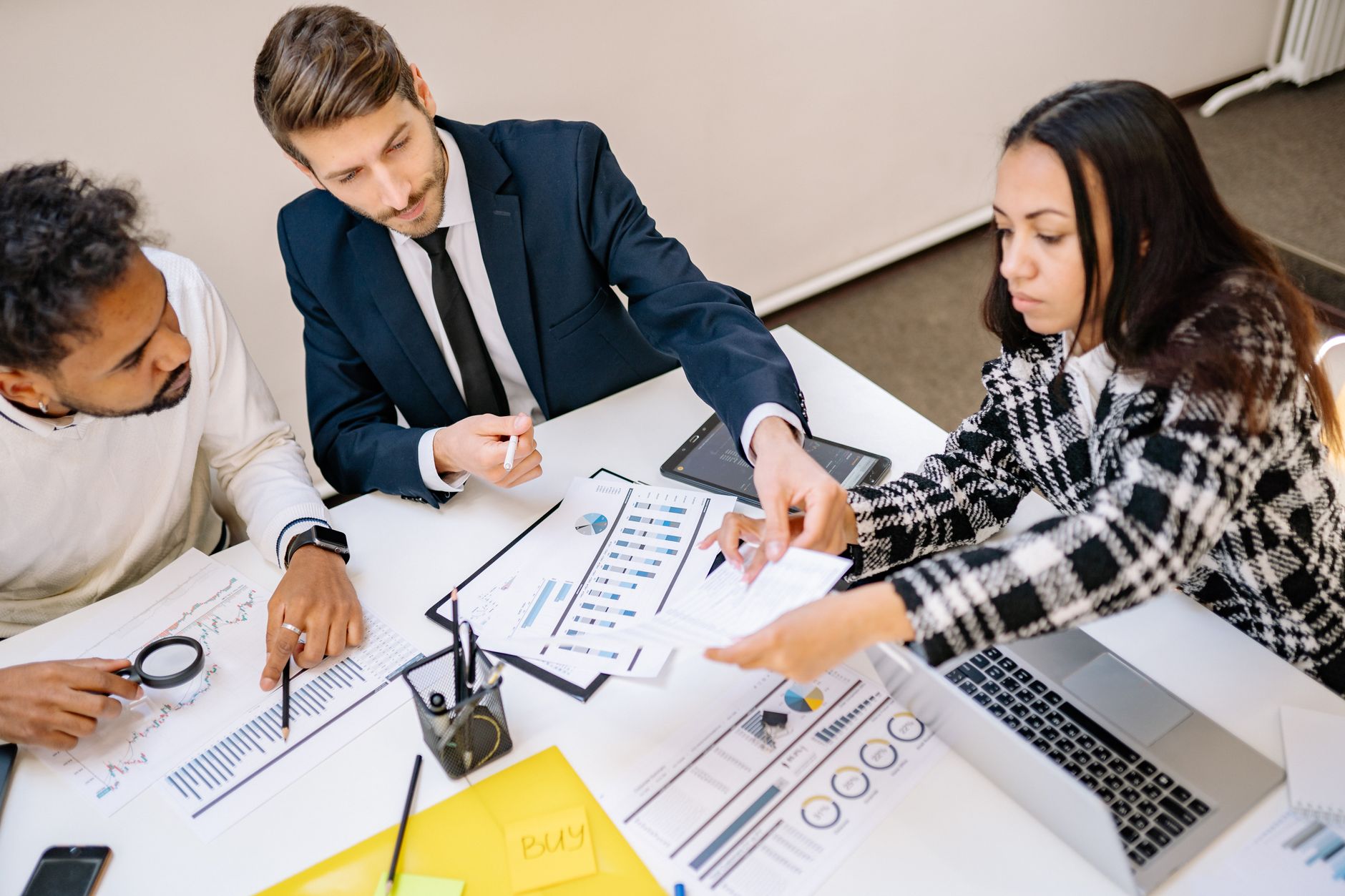 Business team discussing multi-currency payout operations around conference table